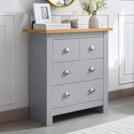 Grey 5-drawer chest with silver handles, placed next to decorative items, flowers, and books.