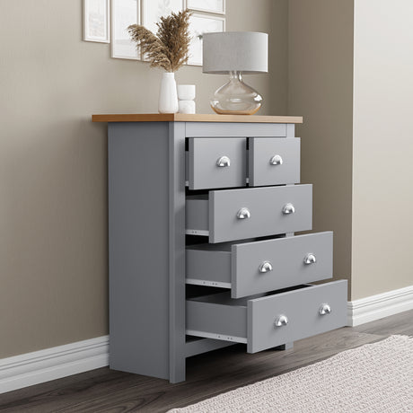 Grey and pine chest of drawers with a top surface decorated with flower pots.