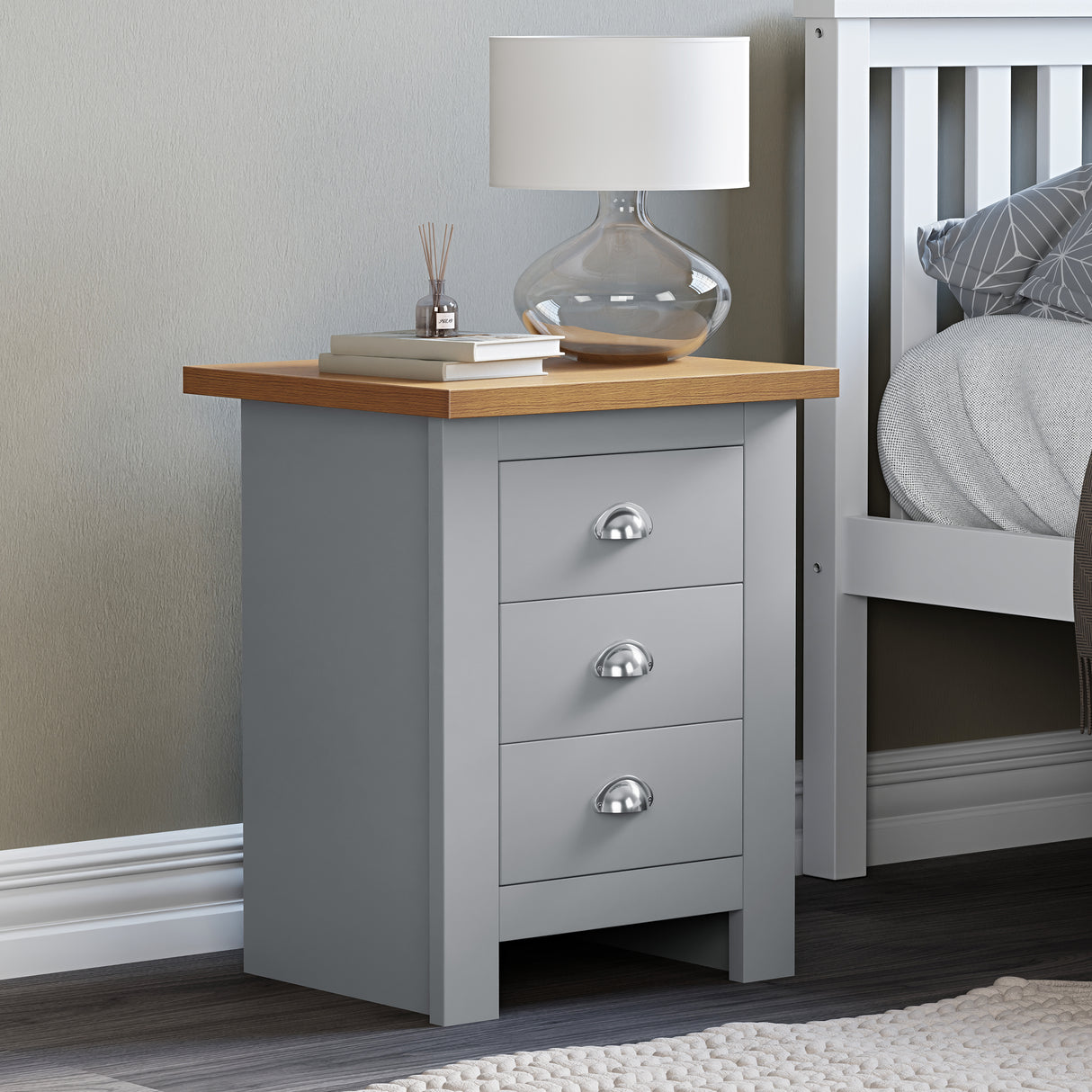 Grey bedside table 3 drawer, top surface adorned with books for a stylish, organized look