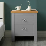 Grey bedside table with two drawers and silver handles, featuring a wooden top.