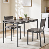 [Grey] Grey breakfast table and two chairs styled with mugs, a fruit bowl and plant beside a bright kitchen diner window.