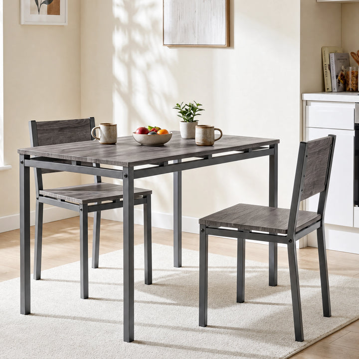 [Grey] Grey breakfast table and two chairs styled with mugs, a fruit bowl and plant beside a bright kitchen diner window.
