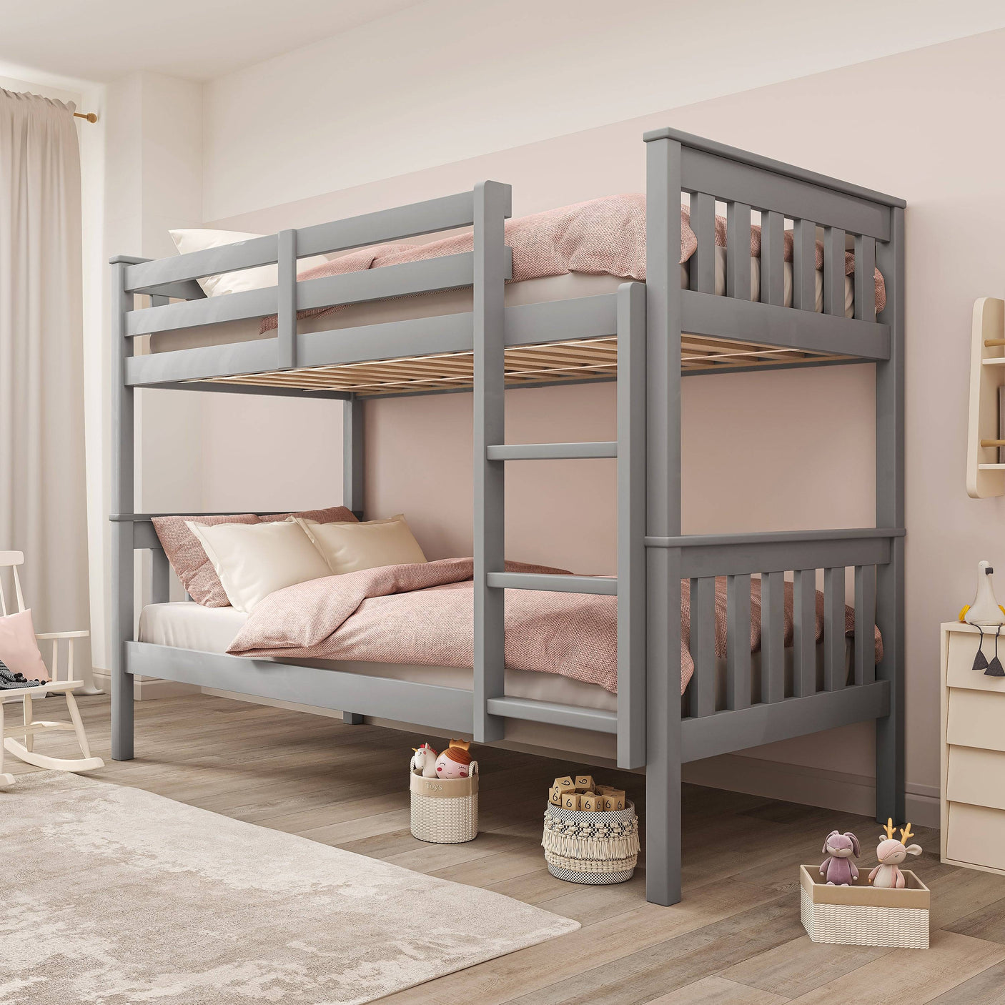 Grey kids' bunk bed with pink bedding in a bright room, featuring a detachable frame and built-in ladder for safe access.