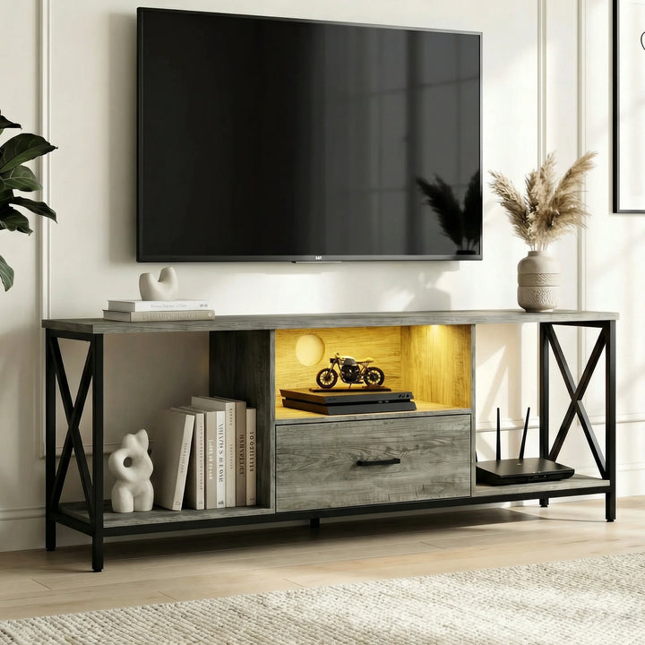 [Grey] Calvera TV stand in a bright living room with wall-mounted TV above, warm amber LED in the centre shelf, games console inside, books and sculpture to the left