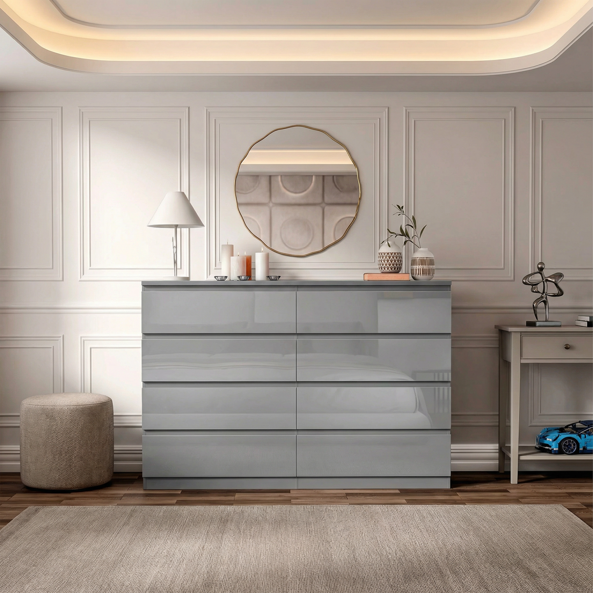 Grey high gloss eight chest of drawers placed against a wall in a modern room with a large round mirror and decorative items