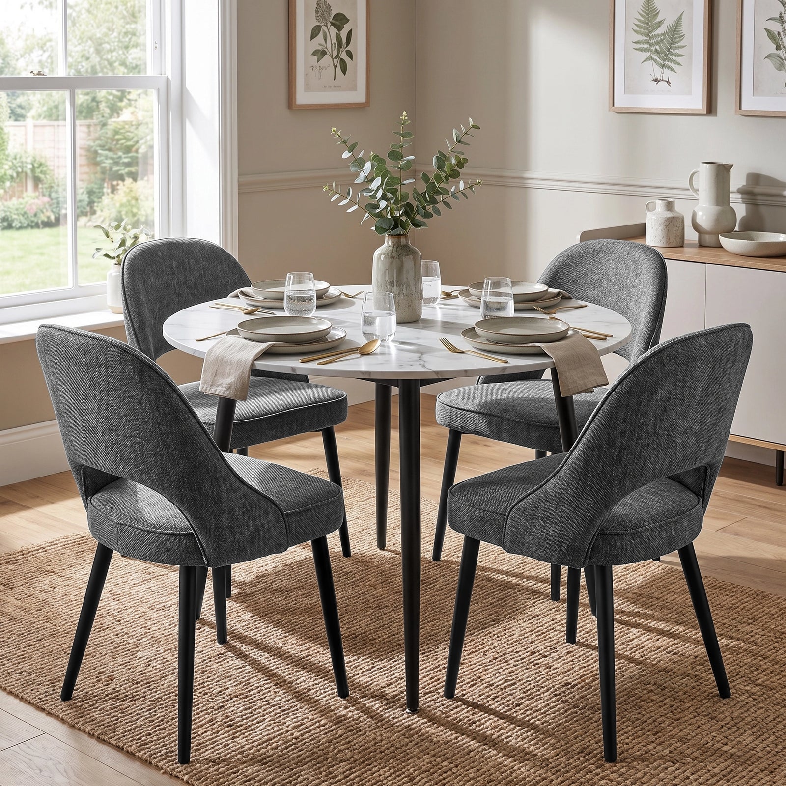 [Grey | Set of 4] Four curved-back dining chairs with padded seats around a round white dining table in a bright dining room.