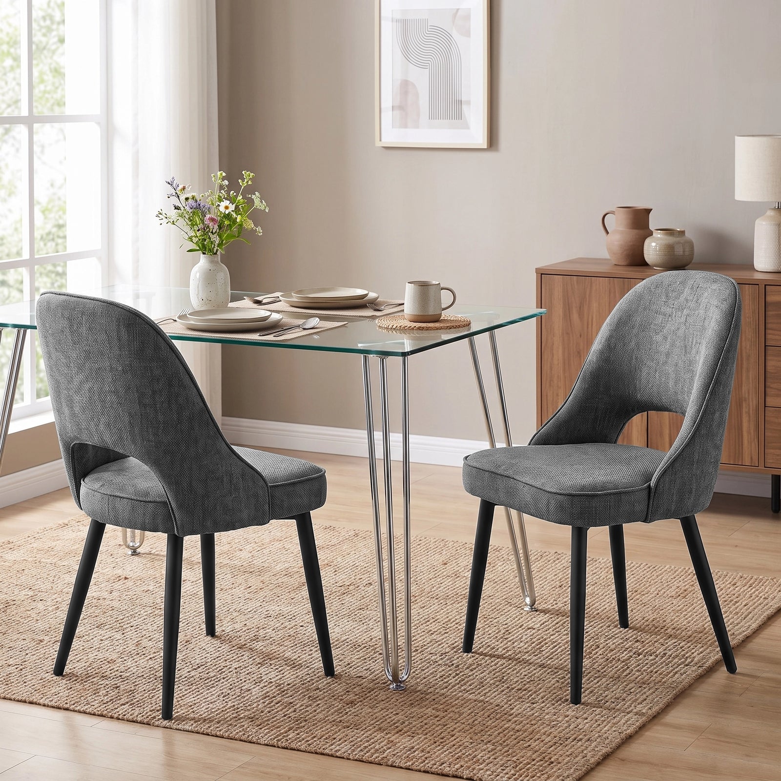 [Grey | Set of 4] Pair of fabric dining room chairs at a glass table, showing curved open backs and black metal legs