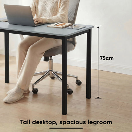 [120 X 50 cm] Computer Desk shown with woman working on laptop, highlighting 75cm tall desktop and spacious legroom for comfortable seating