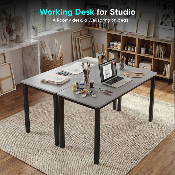 [120 X 50 cm] Computer Desk arranged in artist studio with sketches, paint tubes, brushes in jars, pencils, and laptop on a soft area rug