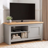 [Grey] TV stand with a light wood top, shown in a styled room setting with a flat-screen TV, a small potted plant, and decorative items on and inside the shelves