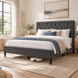 [Double | Grey] Angled bedroom view showing a robot vacuum beneath the bed frame, tufted headboard, bedding, and woven rug.