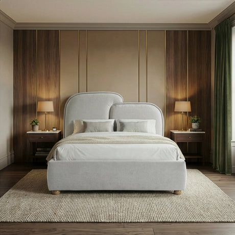 Front-facing view of a grey double bed with padded headboard, neutral linens, and symmetrical bedside tables