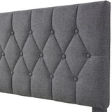 Close-up of a grey double bed frame headboard with tufted button detailing and fabric upholstery.