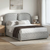 [King | Grey] Embracea upholstered bed in angled lifestyle shot with oak nightstands, linen rug, and neutral bedroom styling