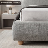 Detail of the double bed front corner showing the upholstered base, rounded and sturdy wooden legs