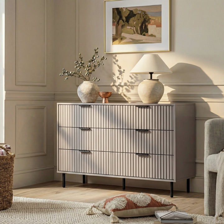 [Grey] Flutrina dresser in a neutral room setting with framed artwork, table lamp and accent chair