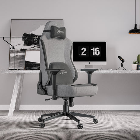 Xstriker Ergonomic Fabric Reclining Gaming Chair with 4D Armrest for Adults in grey, placed in a modern home office setup with a desktop computer and accessories.