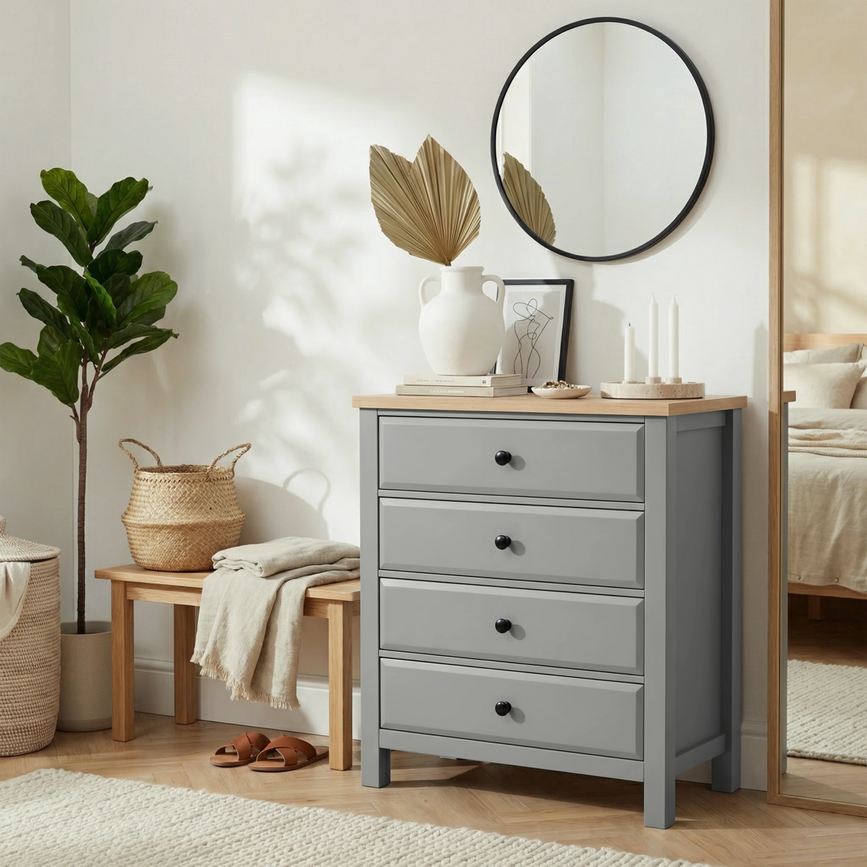 [Grey] Haven 4 drawer chest in a bright airy bedroom with a round mirror, fiddle leaf plant and wicker storage basket