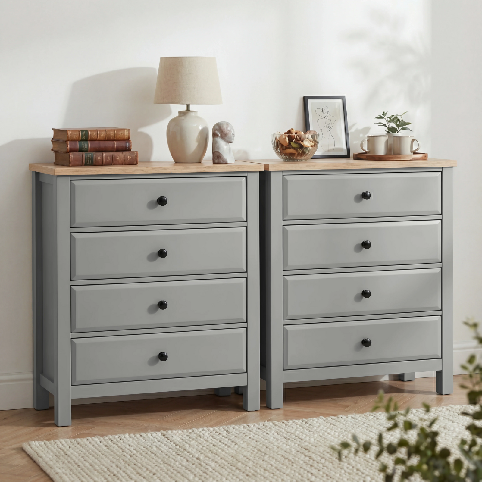 [Grey] Haven 4 drawer chest shown as a matching pair side by side with a table lamp, stacked books and decorative objects