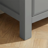 [Grey] Haven chest close-up of the solid square grey painted leg resting on warm oak herringbone parquet flooring