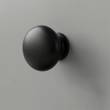 [Grey] Haven close-up of matte black round drawer knob set against light grey painted drawer front