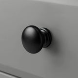 [Grey] Haven close detail of black round knob on smooth drawer front with softly bevelled panel edge
