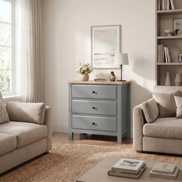 [Grey] Haven lifestyle room view with three drawers, oak-effect top, sofas, window, wall art, and shelving