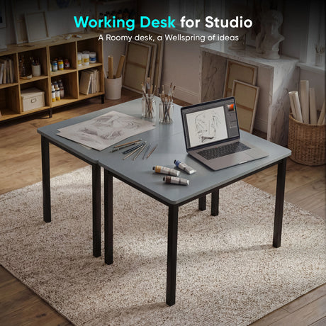 [80 X 50 cm] Home Office Desk arranged in artist studio with sketches, paint tubes, pencils, brushes in jars, and laptop on a soft rug 