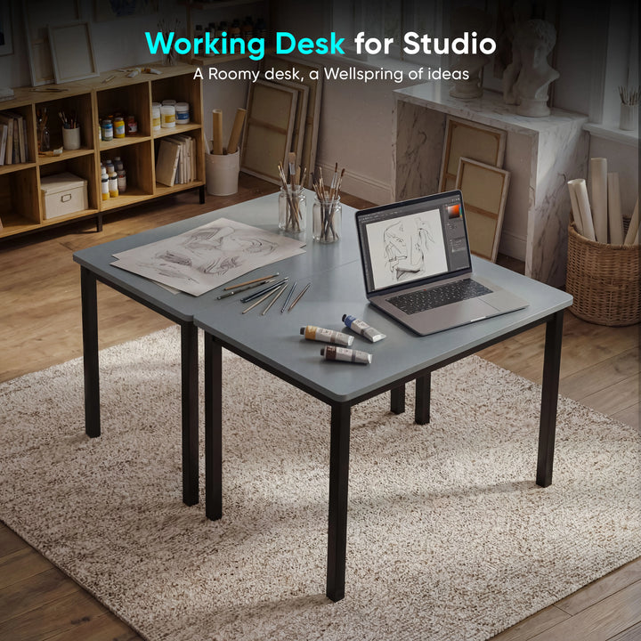 [80 X 50 cm] Home Office Desk arranged in artist studio with sketches, paint tubes, pencils, brushes in jars, and laptop on a soft rug 