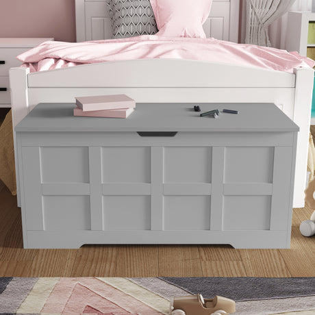Shaker style toy storage box with lid in gray placed at the foot of a white bed, ideal for organizing toys or blankets in kids' bedrooms.