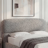 Close detail of a grey padded headrest with curved edges and textured upholstery in a natural light modern room