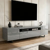 [Grey] Kystra TV stand with wall-mounted black TV above on a panelled wall, vase, books and small sculpture on gloss top
