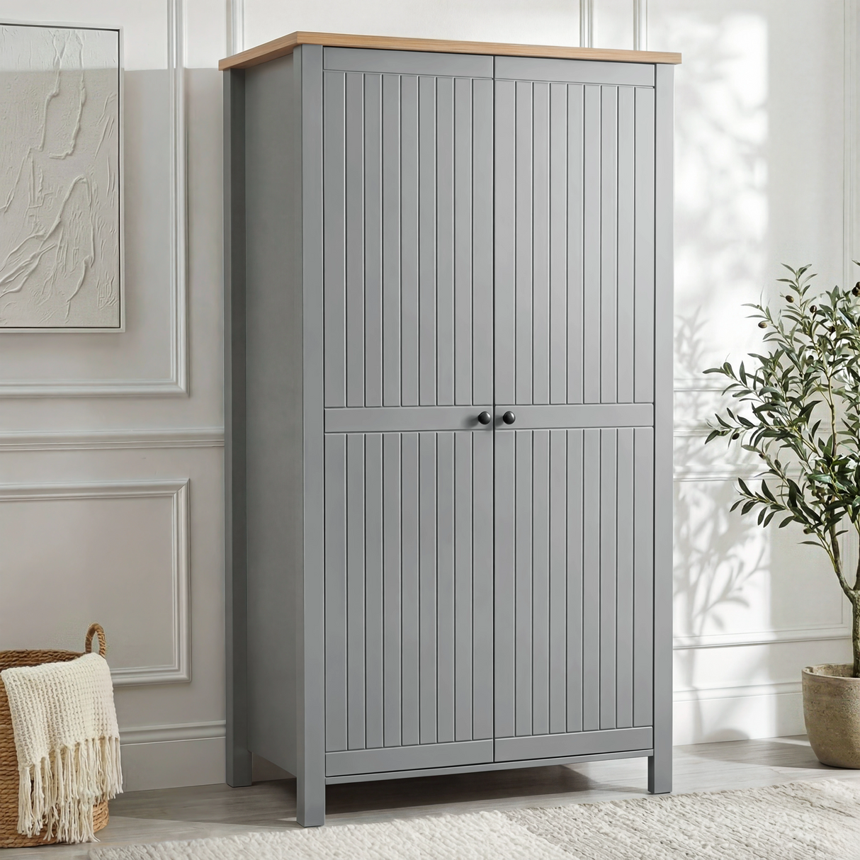 [Grey] Linra 2 Door Wardrobe in a bright white panelled room with woven basket and large olive tree to the right, angle view