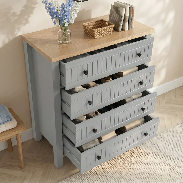 [Grey] Linra Painted 4 Piece Bedroom Furniture Set Grey four-drawer chest with all drawers pulled open showing personal items and accessories stored inside each compartment