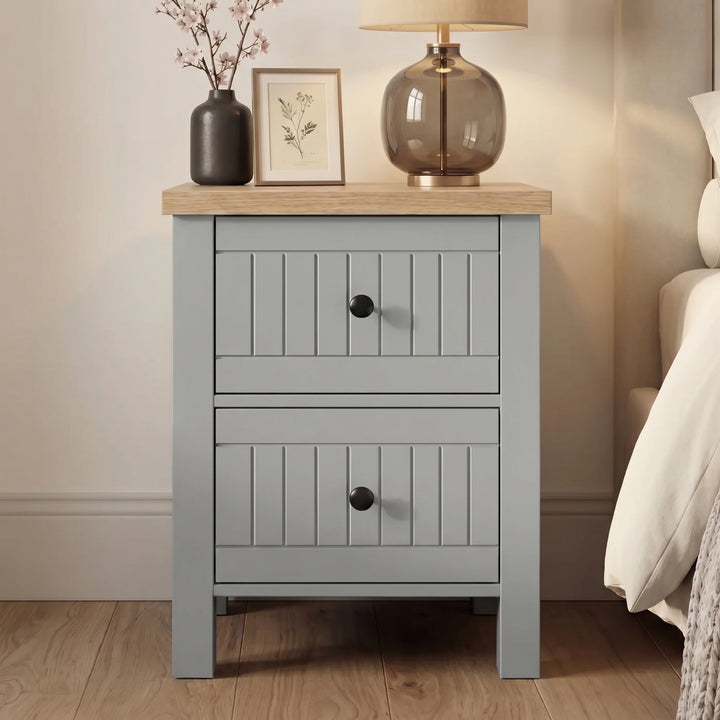 [Grey] Linra Painted 4 Piece Bedroom Furniture Set Grey two-drawer slatted front bedside table sitting next to a bed.