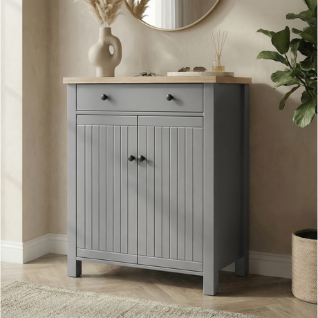[Grey] Linra shoe cabinet front view with oak top, top drawer, grooved double doors, and black knobs in a warm hallway
