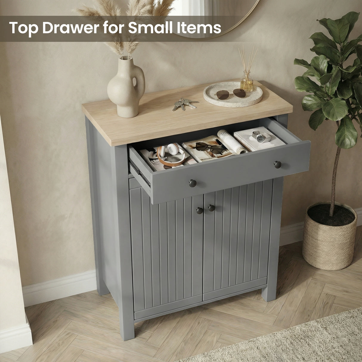 [Grey] Linra shoe cabinet with top drawer pulled open holding headphones, sunglasses, and watch in a warm hallway setting