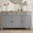 [Grey] Linra straight front detail showing three drawers, beadboard doors, oak-effect top, lamp, and vases