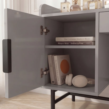 Close-up view of the grey dressing table with open shelves, displaying storage items like books and other items