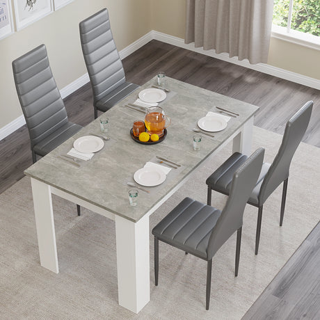 Top view of grey marble dining table set with 4 grey chairs, styled with plates and drinks for a modern look.