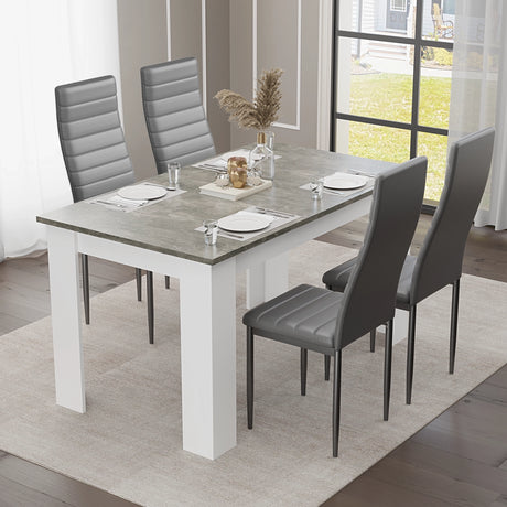 grey marble dining table set with 4 grey PU leather chairs in a bright dining room with large windows.