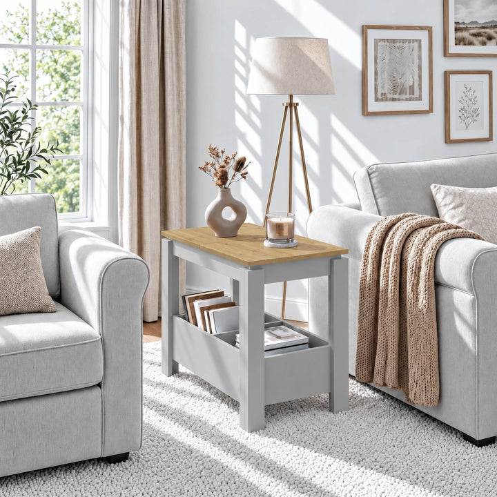 [Grey] Sunlit living room with a side table between two seats, a vase on the wood-effect top and books below.
