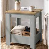 [Grey] Angled view of the square side table beside a sofa, with a folded throw and basket in the open lower storage