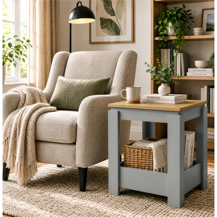 [Grey] Square side table in a living room beside an armchair, with a basket, books and throw stored below