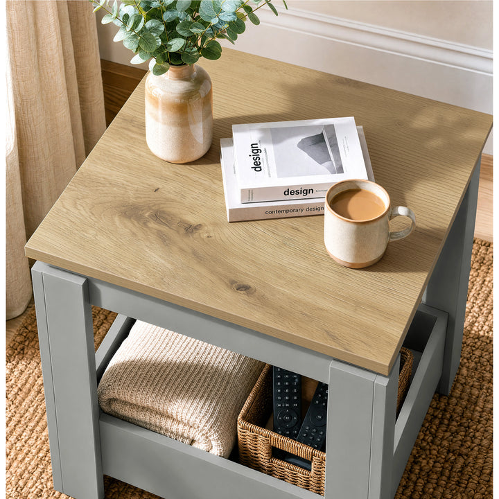[Grey] High-angle view of the square side table top and lower storage with a basket and folded throw