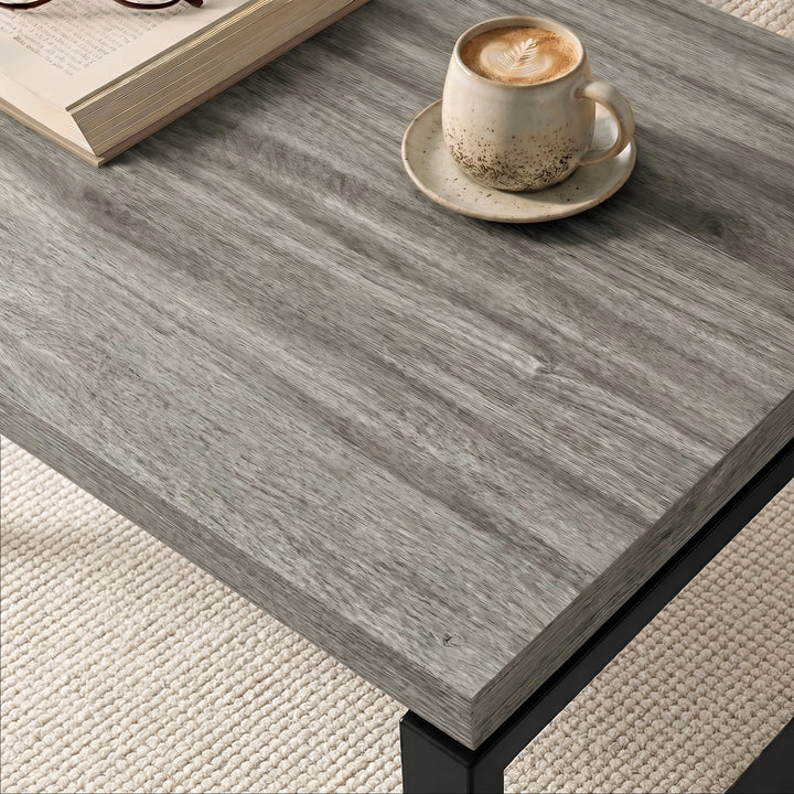 [Grey Oak] Nestline tabletop detail with a small cup on grey wood grain and softly layered edge lines