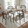 [Grey] Torvi dining table and four black metal armchairs with spindle backs and wood seats, styled with place settings and a glass vase centrepiece