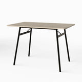 [Grey Oak] Torvi dining table angled on white background showing grey oak MDF top and black metal A-frame legs
