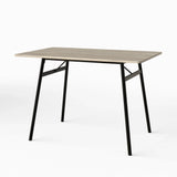 [Grey] Torvi dining table angled on white background showing grey oak MDF top and black metal A-frame legs