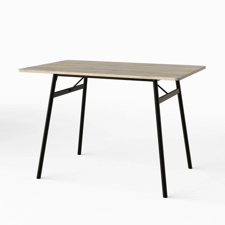[Grey] Torvi dining table angled on white background showing grey oak MDF top and black metal A-frame legs